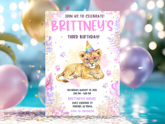 Watercolor girl's lion birthday invitation featuring a lion cub with rainbow heart glasses and party hat, surrounded by pink and purple tropical leaves and gold accents.

