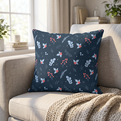 Throw pillow on a beige sofa displaying an elegant dark blue Christmas pattern with holly leaves and snowflakes.