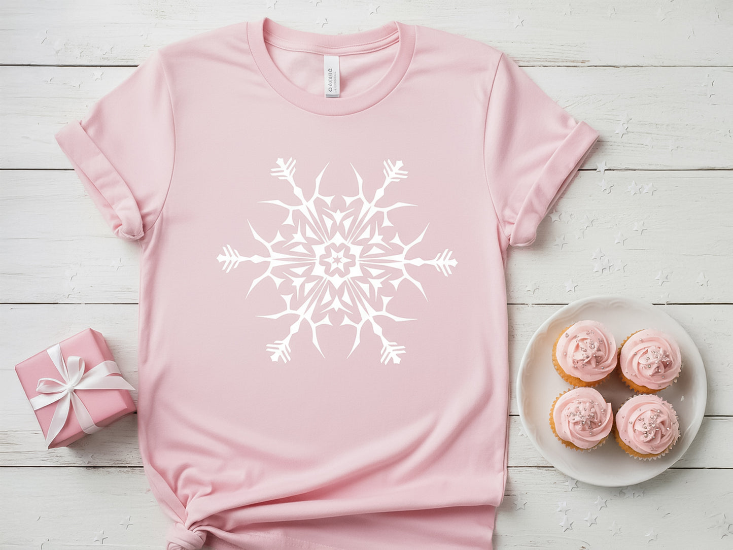 Pink t-shirt featuring a large white snowflake mandala design.